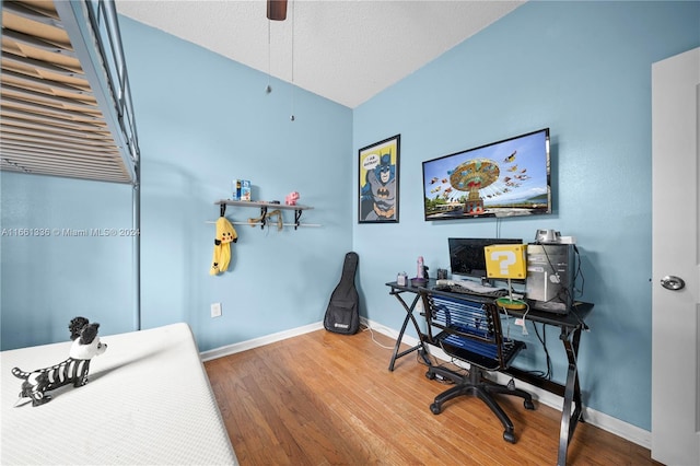 office area featuring vaulted ceiling, wood-type flooring, and a textured ceiling