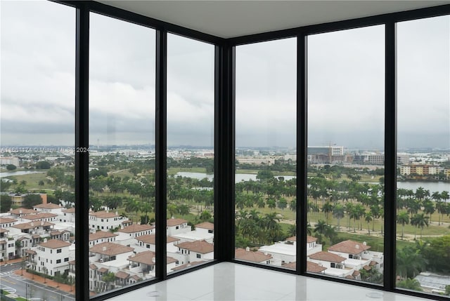 interior space featuring floor to ceiling windows, a water view, and a healthy amount of sunlight