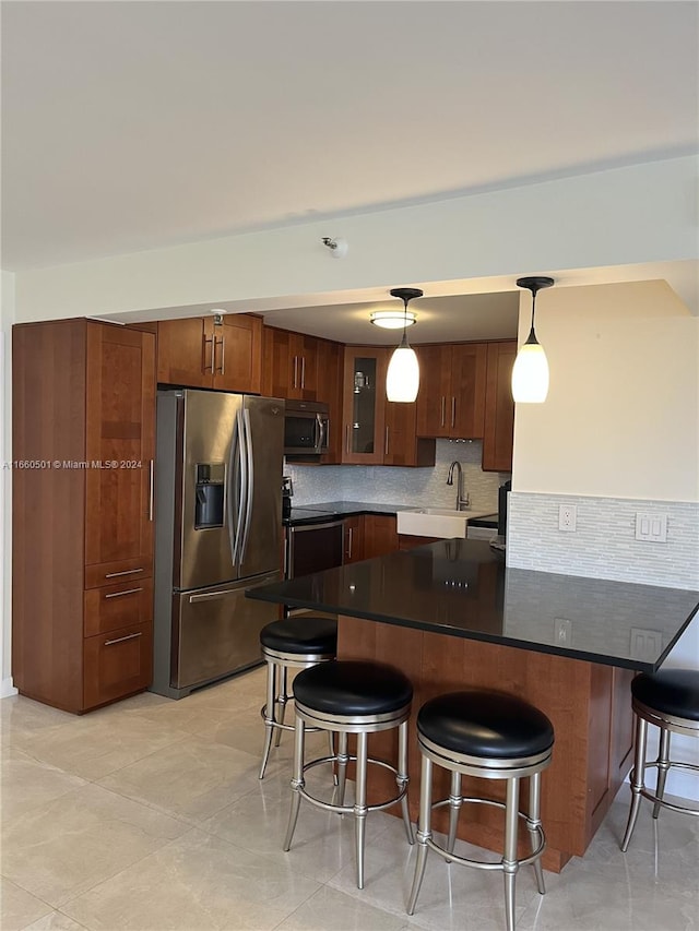 kitchen featuring pendant lighting, light tile patterned flooring, decorative backsplash, a kitchen breakfast bar, and appliances with stainless steel finishes