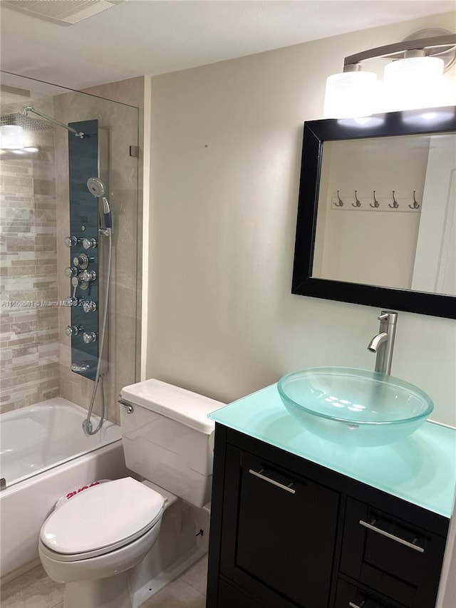 full bathroom with tiled shower / bath combo, tile patterned flooring, vanity, and toilet