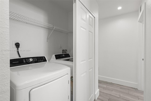 washroom with light wood-type flooring and washer and clothes dryer