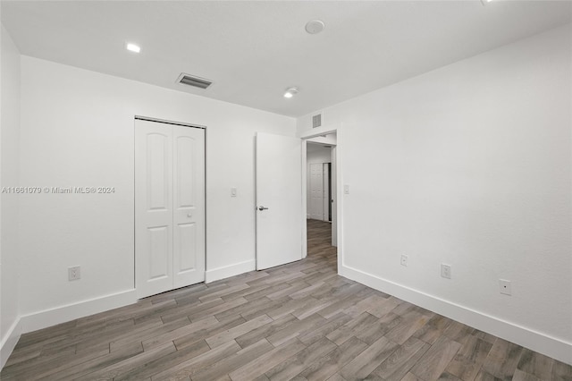 unfurnished bedroom featuring light hardwood / wood-style floors and a closet