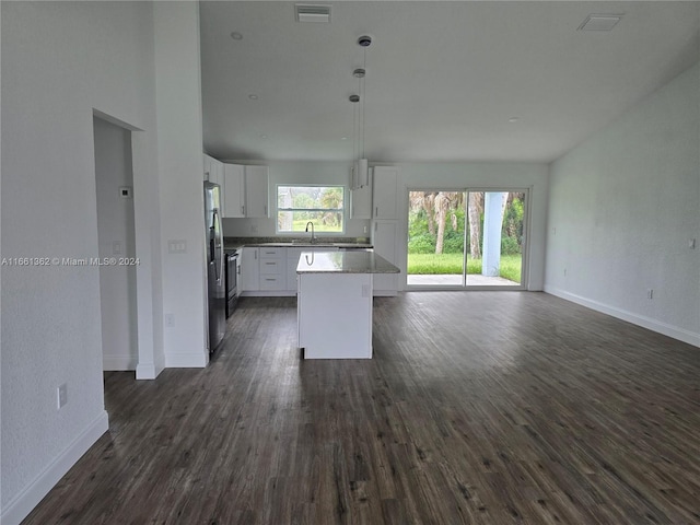 kitchen featuring stainless steel fridge, a kitchen island, dark wood-type flooring, and white cabinets