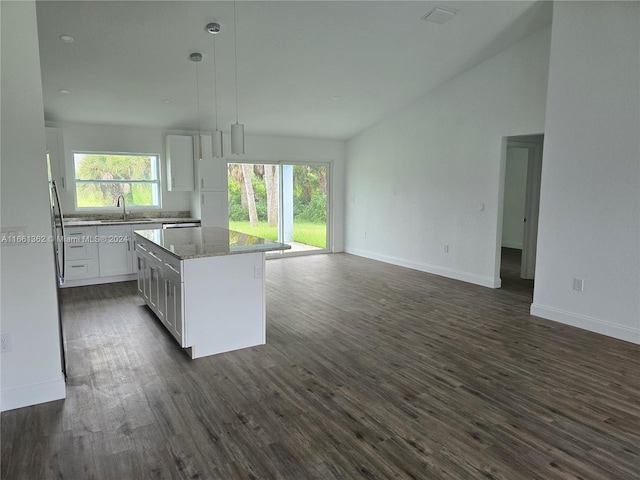 kitchen with sink, decorative light fixtures, white cabinetry, dark hardwood / wood-style floors, and a center island