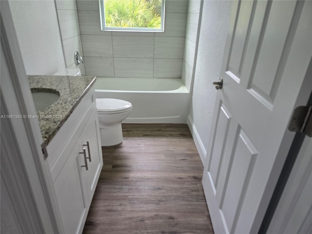 full bathroom with wood-type flooring, vanity, toilet, and tiled shower / bath combo