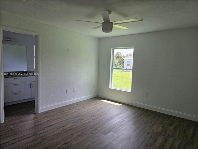 unfurnished room featuring ceiling fan, a textured ceiling, and dark hardwood / wood-style flooring