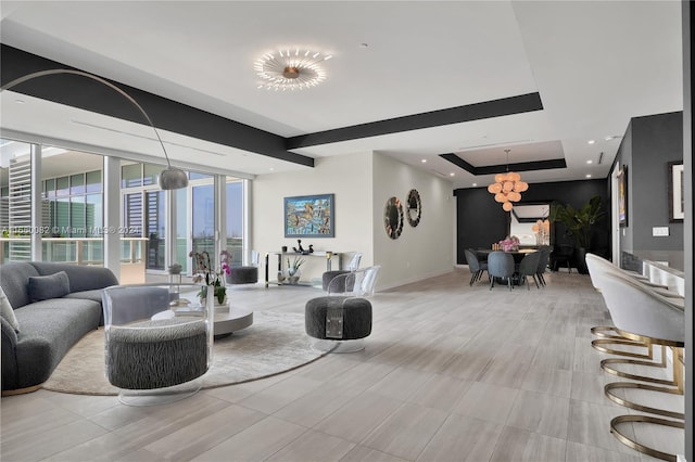 living room with a notable chandelier and a tray ceiling