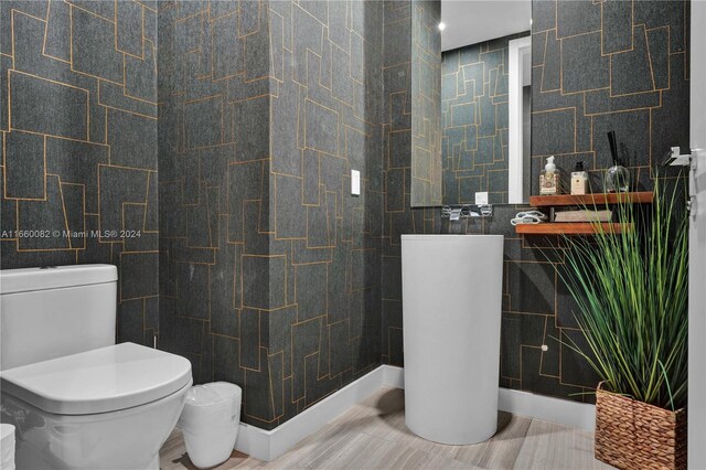 bathroom featuring tile walls and toilet