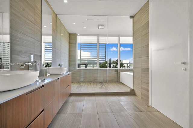 4701 N Meridian Ave Unit 510, Miami Beach, FL 33140 - bathroom featuring tile walls, double vanity, and a soaking tub