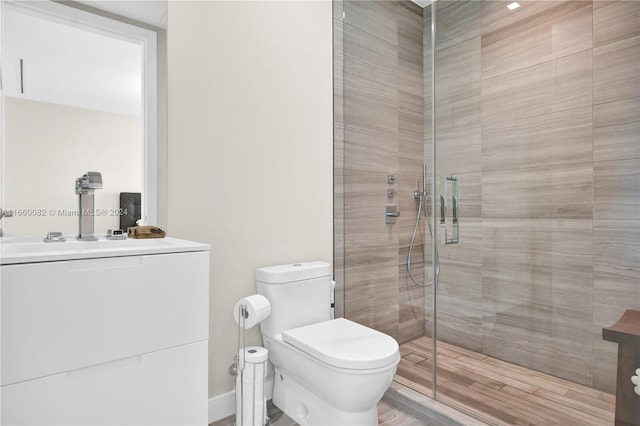 bathroom with vanity, toilet, a shower with door, and hardwood / wood-style flooring