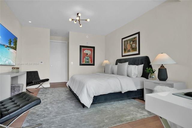 bedroom featuring wood-type flooring and a chandelier