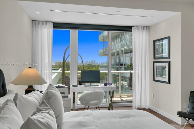 4701 N Meridian Ave Unit 510, Miami Beach, FL 33140 - bedroom with floor to ceiling windows, baseboards, multiple windows, and wood finished floors
