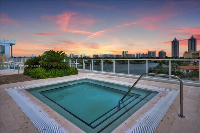 4701 N Meridian Ave Unit 510, Miami Beach, FL 33140 - pool at dusk featuring a water view, a swimming pool, and a view of skyline