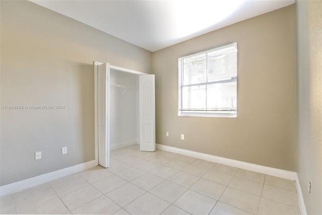 unfurnished bedroom with a closet and light tile patterned floors