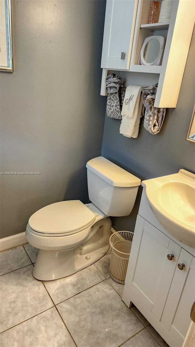 bathroom with toilet, vanity, and tile patterned floors