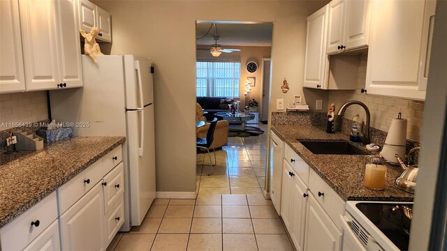 kitchen featuring ceiling fan, sink, white cabinetry, and backsplash