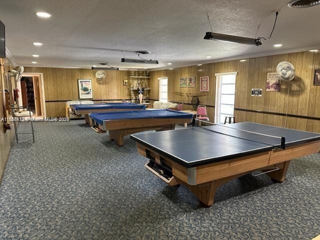 game room featuring carpet floors, a textured ceiling, pool table, and wood walls