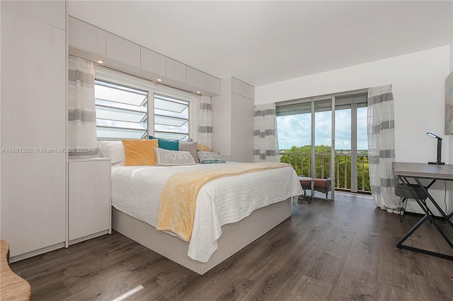 bedroom featuring multiple windows, dark hardwood / wood-style floors, and access to outside