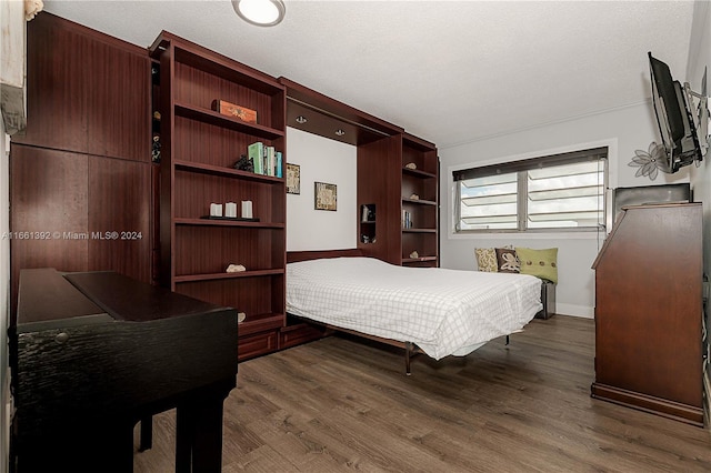 bedroom with a textured ceiling and dark wood-type flooring