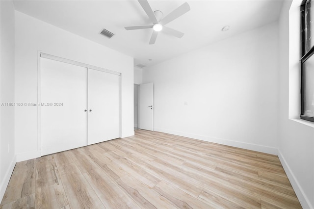 unfurnished bedroom with ceiling fan, light hardwood / wood-style flooring, and a closet