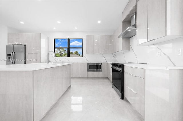 kitchen with appliances with stainless steel finishes, backsplash, sink, and wall chimney range hood