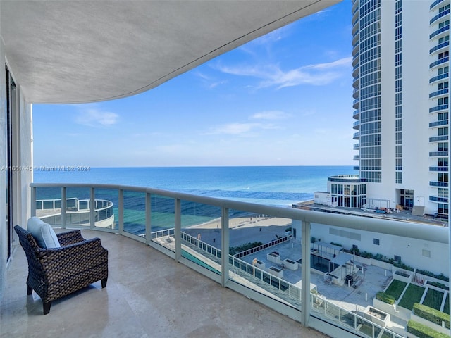 balcony featuring a water view and a view of the beach