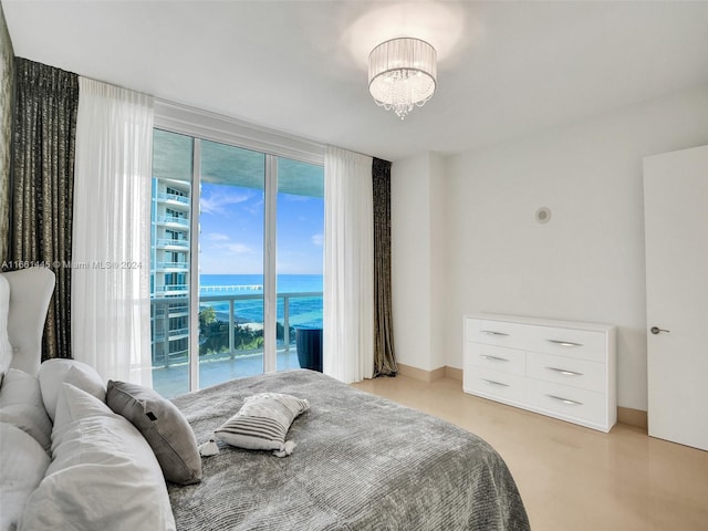 bedroom featuring a water view and an inviting chandelier