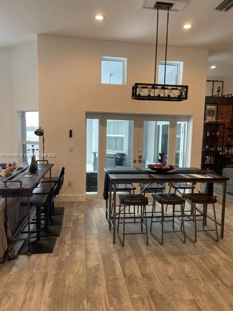 dining space featuring a high ceiling and hardwood / wood-style flooring