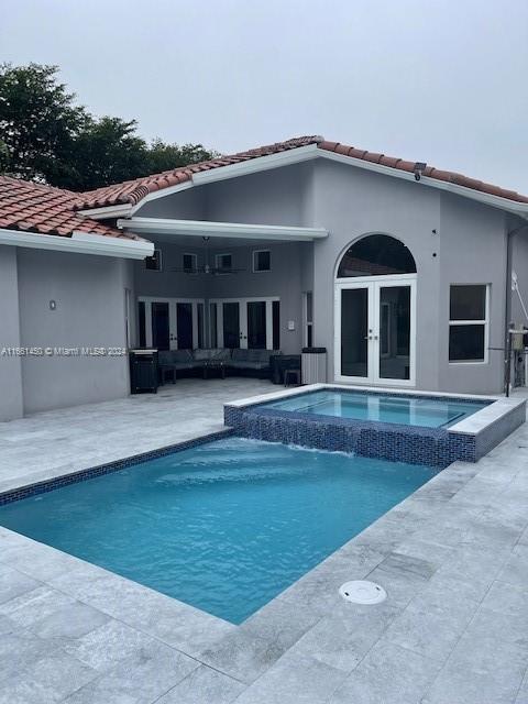 back of property with french doors, an outdoor hangout area, and a patio