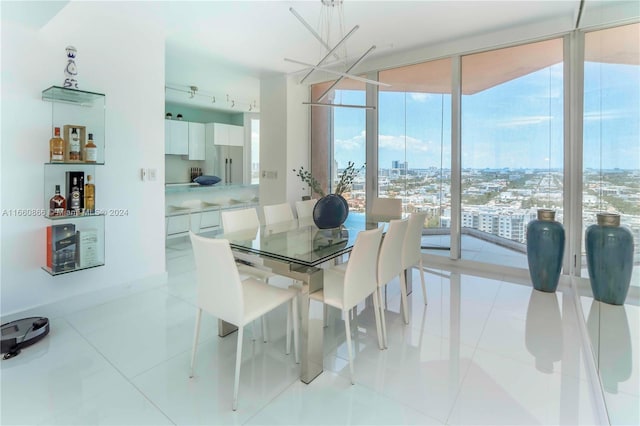 dining room featuring a notable chandelier, floor to ceiling windows, and light tile patterned floors