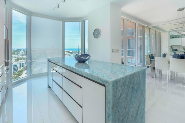 kitchen featuring white cabinetry, floor to ceiling windows, and a wealth of natural light