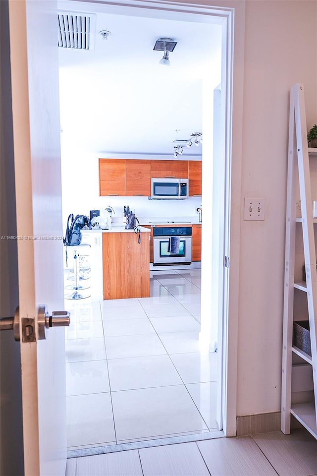 corridor featuring light tile patterned floors