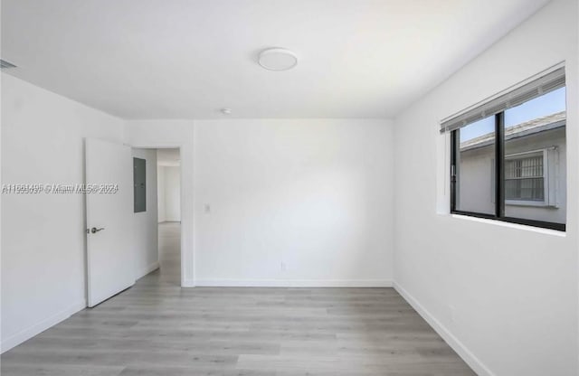 spare room featuring light hardwood / wood-style flooring and electric panel