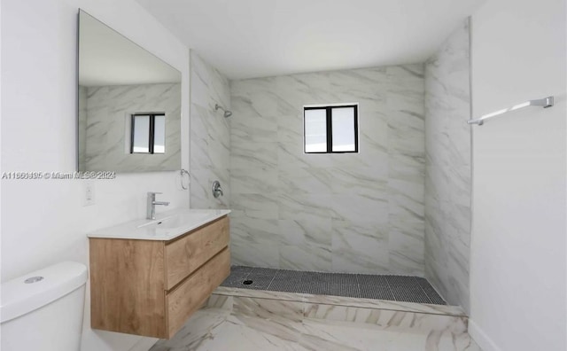 bathroom featuring vanity, toilet, and tiled shower