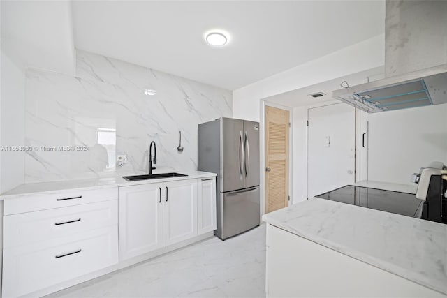 kitchen with white cabinetry, black stove, stainless steel refrigerator, island exhaust hood, and sink