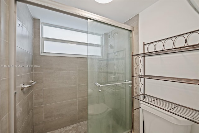 bathroom with toilet and a shower with shower door