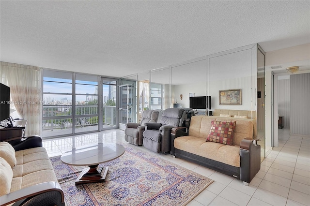 tiled living room with plenty of natural light, expansive windows, and a textured ceiling