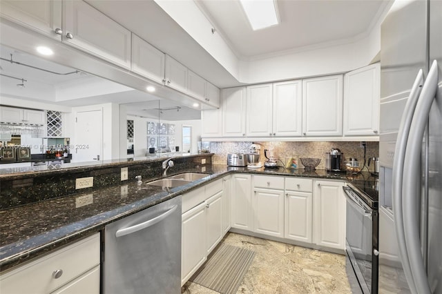 kitchen featuring dark stone counters, sink, stainless steel appliances, and white cabinets