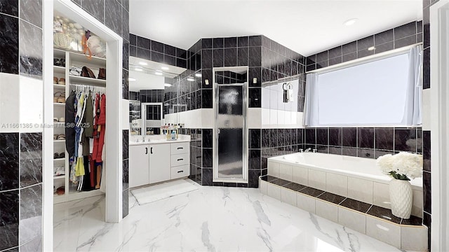 bathroom featuring vanity, tile walls, and independent shower and bath