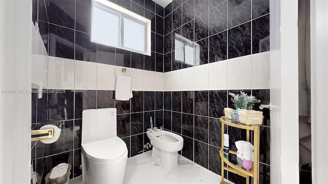 bathroom with a bidet, tile walls, and toilet