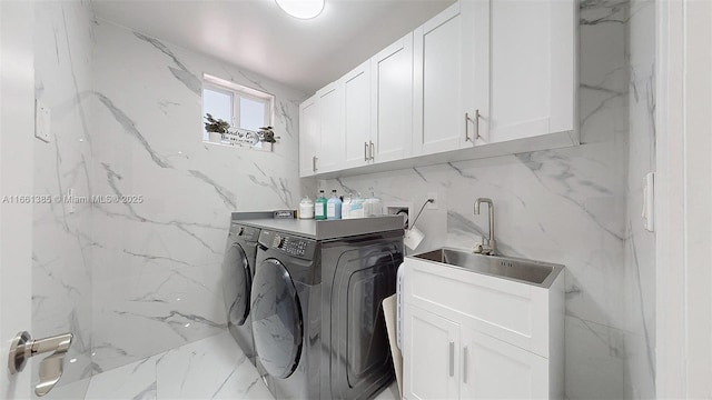 laundry room featuring washer and clothes dryer and cabinets