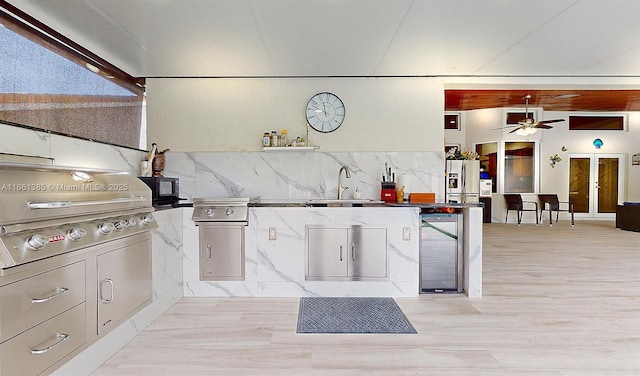 kitchen with ceiling fan, sink, backsplash, stainless steel fridge, and light hardwood / wood-style floors