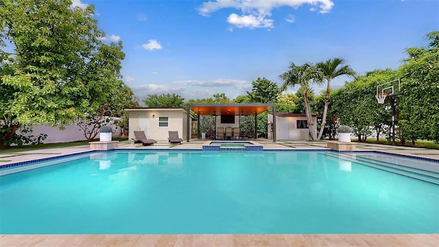 view of pool featuring an in ground hot tub and an outdoor structure