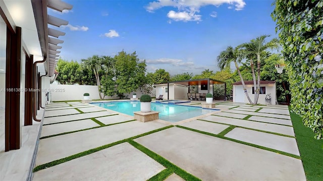 view of pool featuring a patio area and an outbuilding