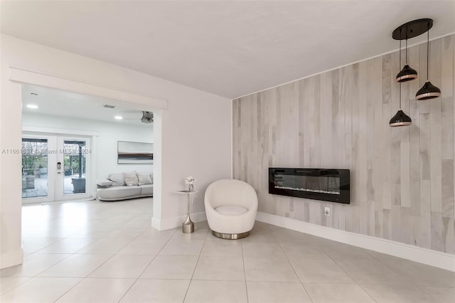 sitting room featuring french doors, heating unit, light tile patterned floors, and a large fireplace