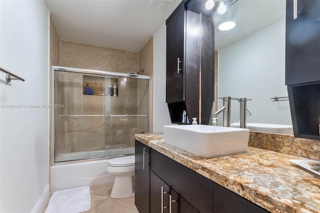 full bathroom with bath / shower combo with glass door, vanity, toilet, and tile patterned floors