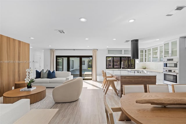 living room featuring recessed lighting, visible vents, and light wood-style flooring