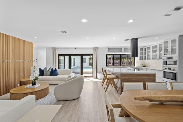 living area featuring recessed lighting, visible vents, and light wood-type flooring