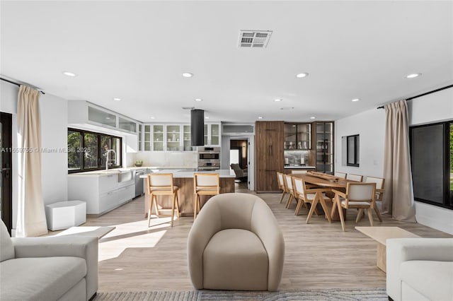 living room featuring recessed lighting, visible vents, and light wood-type flooring