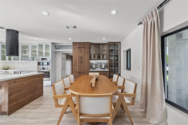 dining room with light wood-type flooring, visible vents, and recessed lighting